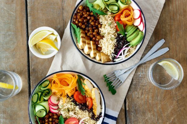 Zwei Buddha Bowls mit Zitronenwasser